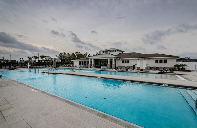 community pool with a patio area and fence