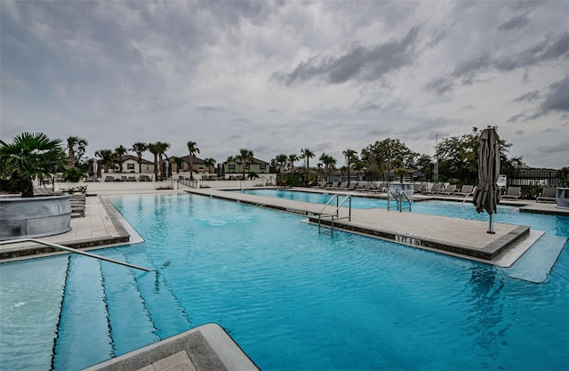 pool with a patio area and fence