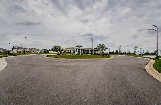 view of road with a residential view, curbs, and street lights