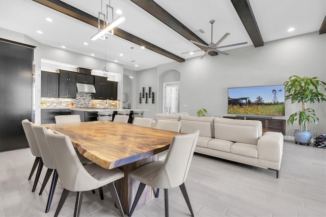 dining area with arched walkways, recessed lighting, a ceiling fan, visible vents, and beam ceiling