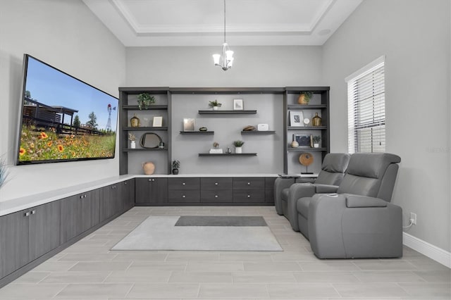 sitting room with baseboards, a tray ceiling, and a chandelier