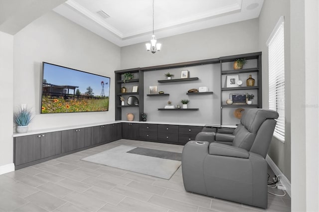 interior space with an inviting chandelier, visible vents, a tray ceiling, and baseboards