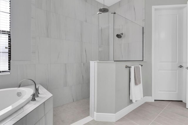 bathroom featuring tile patterned floors, a healthy amount of sunlight, a garden tub, and walk in shower