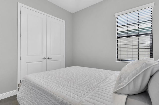 bedroom with carpet, baseboards, and a closet