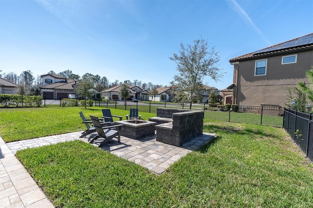 view of yard with a residential view, a fenced backyard, a patio, and a fire pit