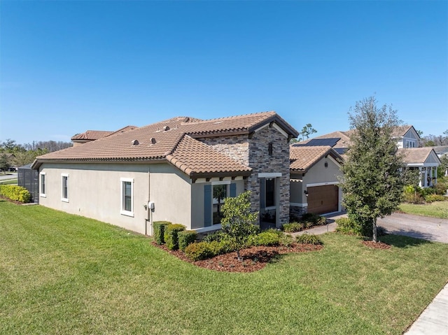 rear view of property with a yard, stucco siding, concrete driveway, a garage, and stone siding