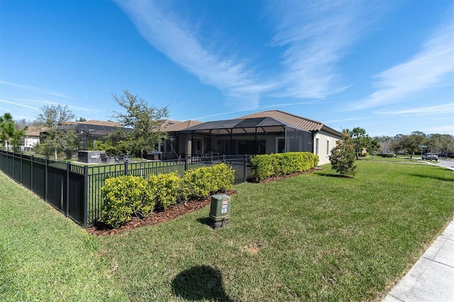 view of yard with glass enclosure and fence