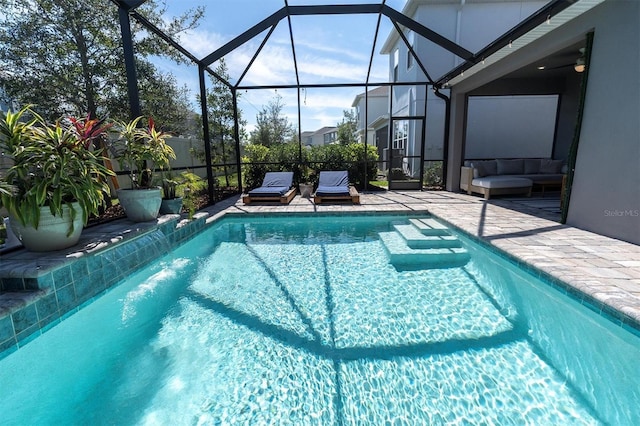 view of pool with a fenced in pool, a lanai, a patio area, and a ceiling fan