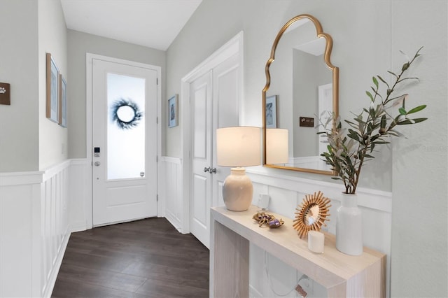 foyer entrance with dark wood-style flooring and wainscoting