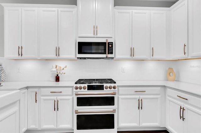 kitchen with tasteful backsplash, white appliances, light countertops, and white cabinetry