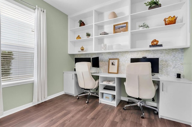 office space with dark wood-style flooring, a wealth of natural light, and baseboards