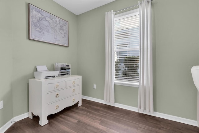 bedroom with dark wood finished floors and baseboards