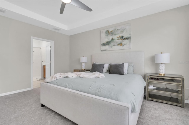 bedroom with baseboards, visible vents, a ceiling fan, a tray ceiling, and carpet floors