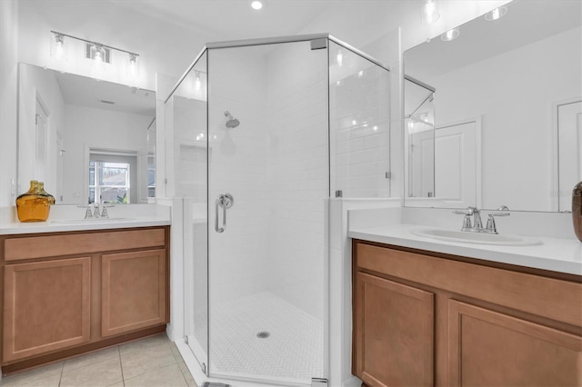 full bath with tile patterned floors, two vanities, a sink, and a shower stall