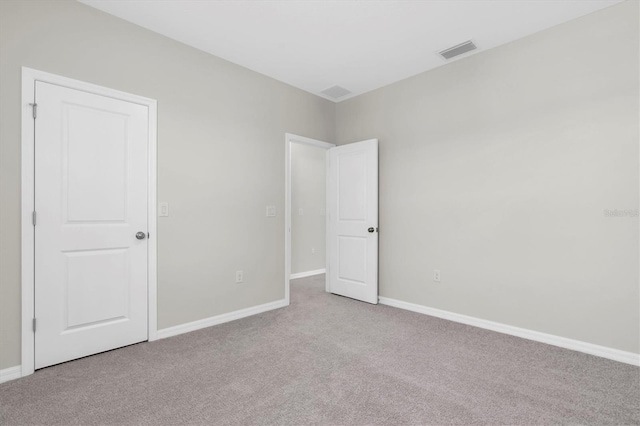 unfurnished room with carpet flooring, visible vents, and baseboards