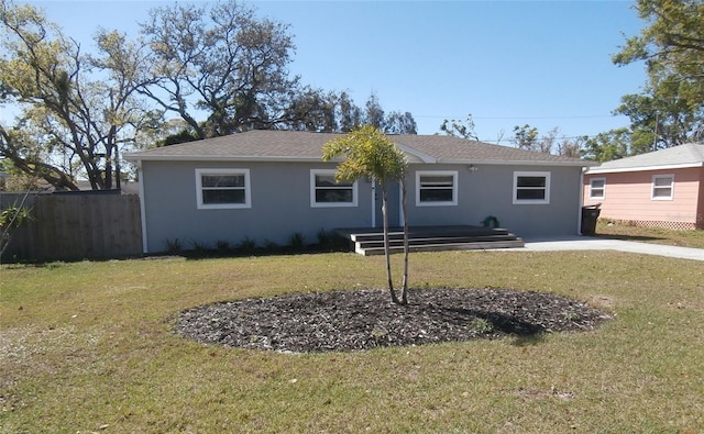 single story home with stucco siding, a front lawn, and fence