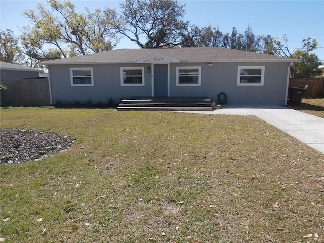 ranch-style home featuring stucco siding, driveway, a front yard, and fence