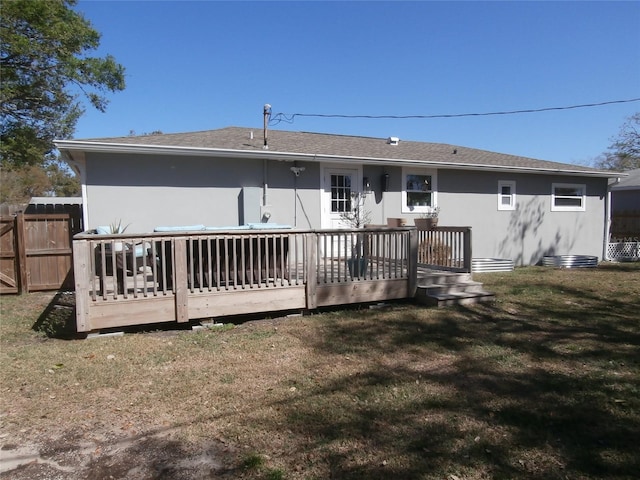 back of house featuring fence, a lawn, and a wooden deck