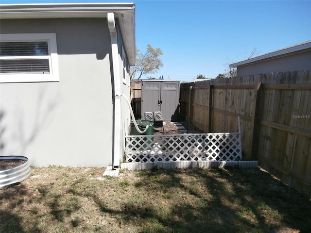 view of yard with an outbuilding, a storage shed, and a fenced backyard