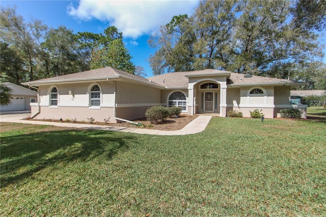 view of front of house with a front yard, an outdoor structure, and stucco siding