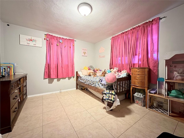 bedroom with tile patterned floors, a textured ceiling, and baseboards