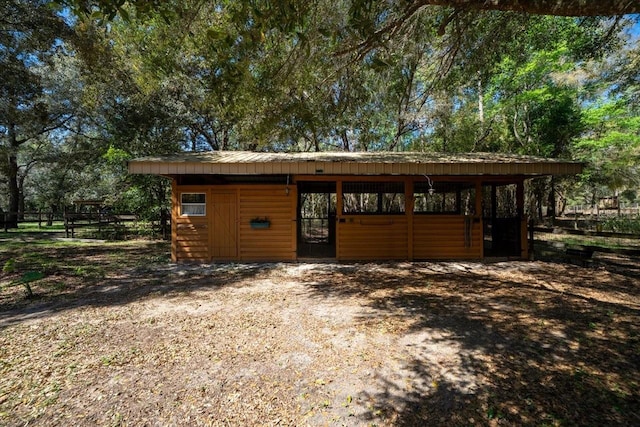 view of outdoor structure featuring a carport, an exterior structure, and an outbuilding