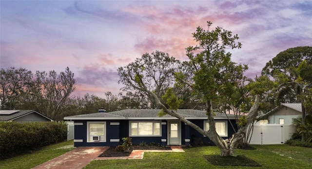 ranch-style house with a front yard, fence, and a gate