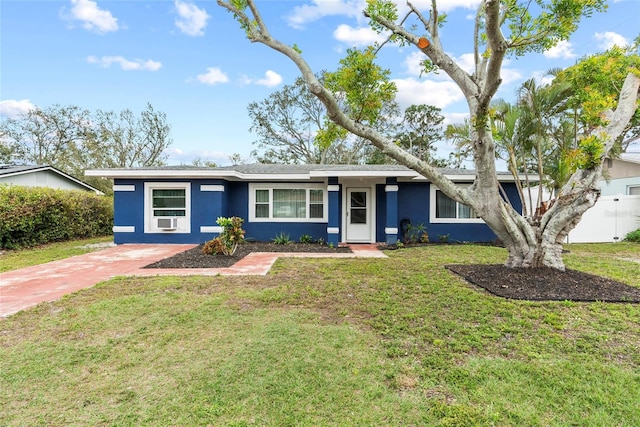 ranch-style home with a front yard, driveway, and stucco siding