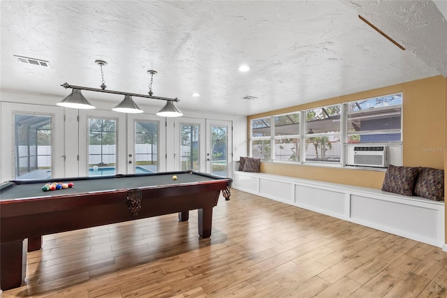 rec room with billiards, visible vents, wood finished floors, cooling unit, and french doors