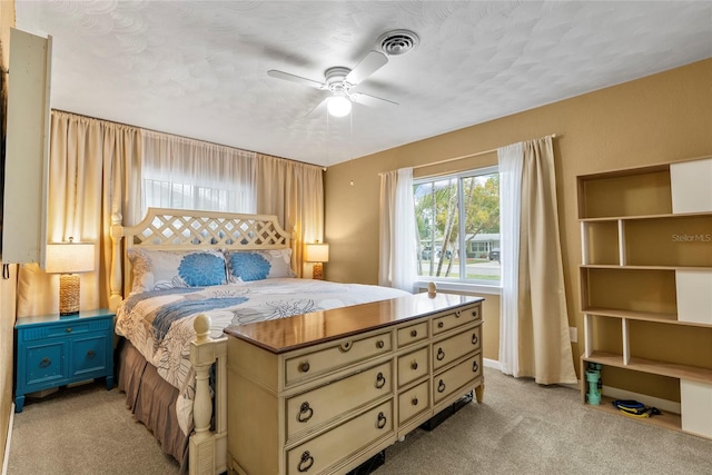 bedroom featuring light carpet, ceiling fan, visible vents, and baseboards