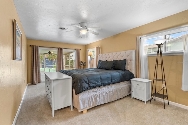 bedroom featuring a textured ceiling, a textured wall, light colored carpet, visible vents, and baseboards