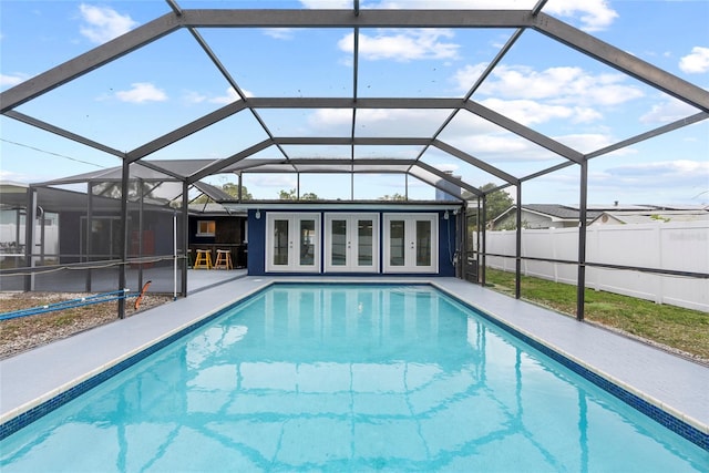 view of pool with a patio, a lanai, fence, french doors, and a fenced in pool