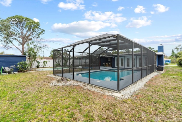 pool featuring an outbuilding, a yard, a patio, and glass enclosure