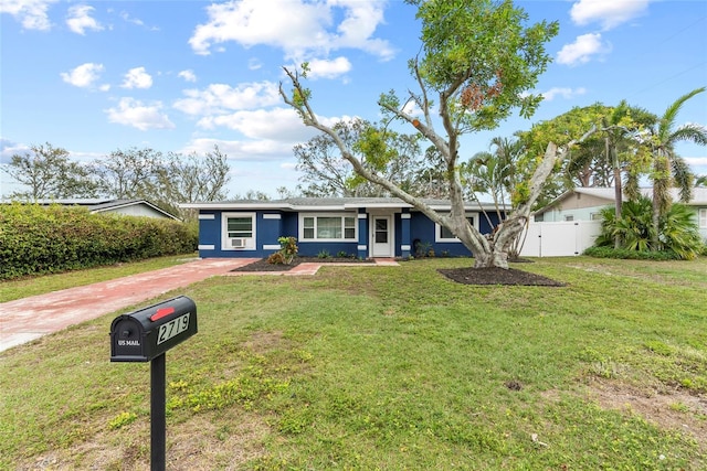 single story home with a front yard, fence, and a gate