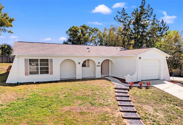 view of front of house with stucco siding, an attached garage, concrete driveway, and a front yard