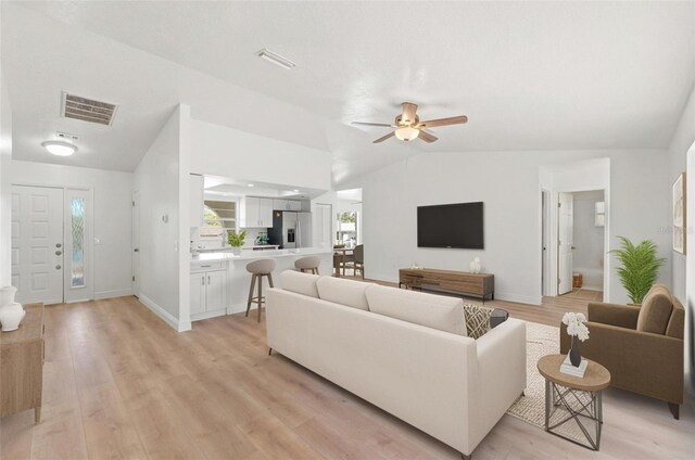 7048 Oberon Ave, Spring Hill, FL 34608 - living area with lofted ceiling, a ceiling fan, light wood finished floors, and baseboards