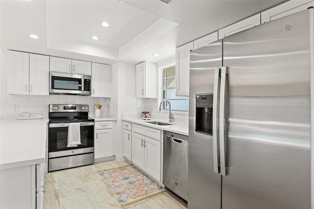 7048 Oberon Ave, Spring Hill, FL 34608 - kitchen featuring appliances with stainless steel finishes, a sink, light countertops, white cabinets, and recessed lighting