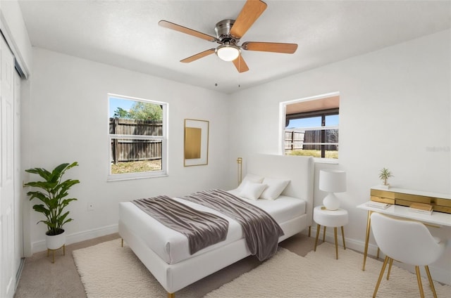 7048 Oberon Ave, Spring Hill, FL 34608 - carpeted bedroom featuring multiple windows, a closet, baseboards, and a ceiling fan