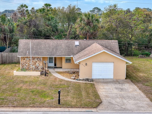 view of front facade with stucco siding, a front lawn, fence, concrete driveway, and a shingled roof