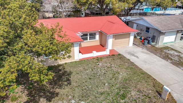 view of front of property with a detached garage, a front lawn, and concrete driveway