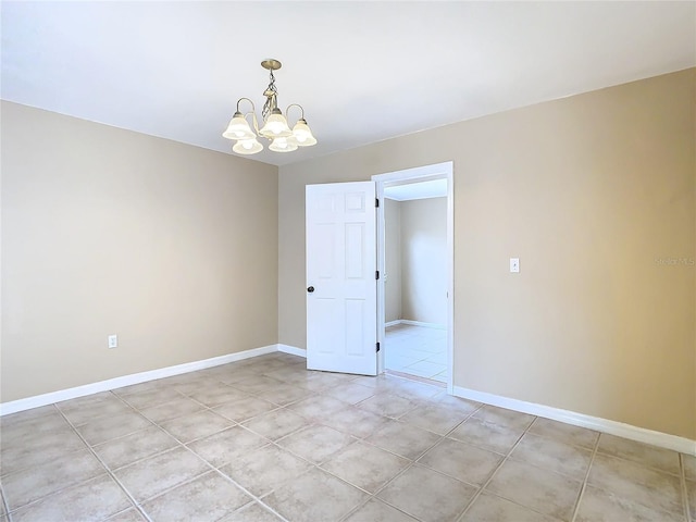 unfurnished room with a chandelier and baseboards