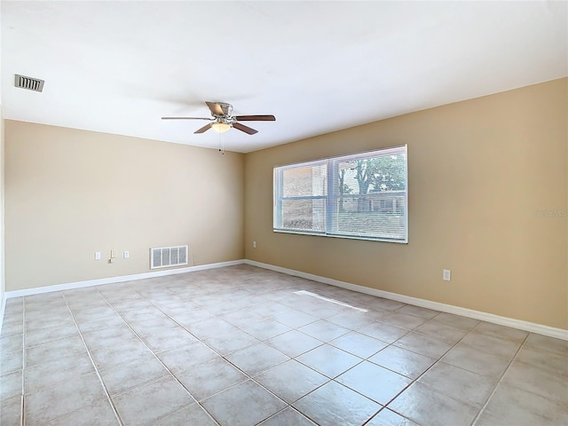 empty room with ceiling fan, visible vents, and baseboards