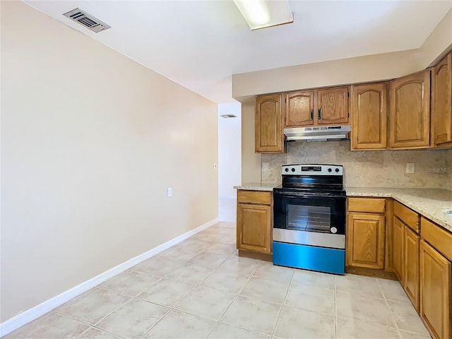 kitchen with electric range, visible vents, brown cabinetry, under cabinet range hood, and backsplash