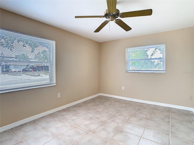 empty room featuring ceiling fan, baseboards, and light tile patterned flooring