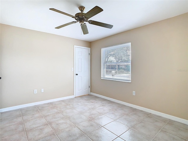 unfurnished room with a ceiling fan, light tile patterned flooring, and baseboards