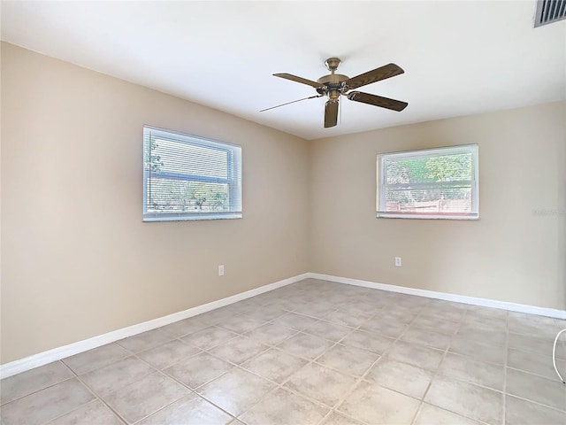 empty room featuring plenty of natural light, visible vents, and baseboards