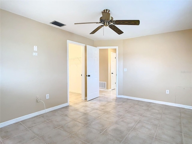 empty room with ceiling fan, visible vents, and baseboards