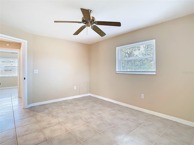 spare room featuring ceiling fan, baseboards, and light tile patterned floors