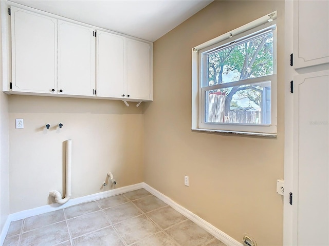 washroom with cabinet space, baseboards, hookup for a gas dryer, washer hookup, and light tile patterned flooring