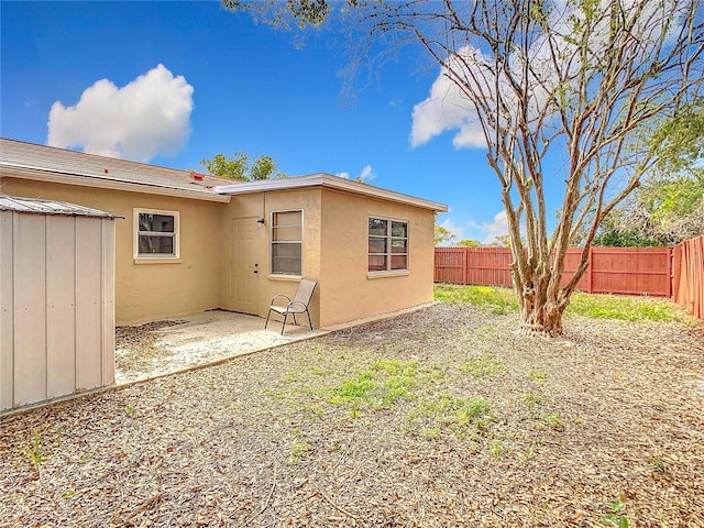 back of house featuring a patio area, a fenced backyard, and stucco siding